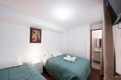 a bedroom with two beds and a mirror at Carmen's House in Cusco