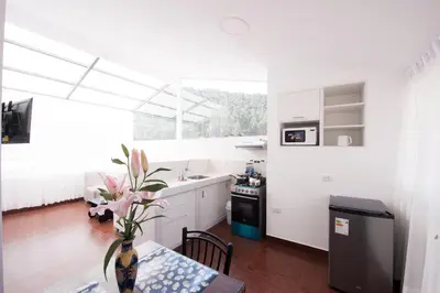 a kitchen with a table and a vase with flowers on it at Carmen's House in Cusco