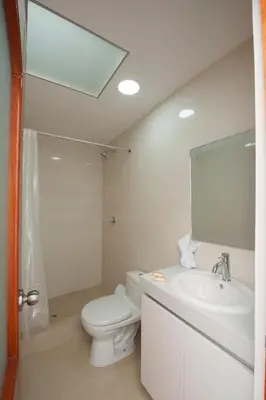a white bathroom with a toilet and a sink at Carmen's House in Cusco