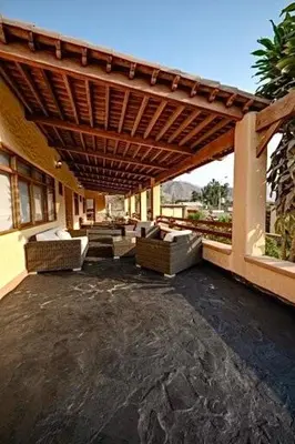 an outdoor patio with couches and a wooden pergola at Casa Trasgu en Cieneguilla Lima Peru Nice and cozy cottage in Villa María del Trunfo
