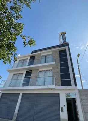 a tall building with blue windows on top of it at Hostal los Ficus in Ica