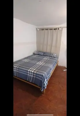 a bedroom with a bed with a blue and white blanket at Casita Monarca in San Antonio