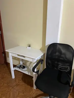 a desk with a black chair next to a white desk at Departamento amplio y cómodo a 15 minutos del aeropuerto in Lima