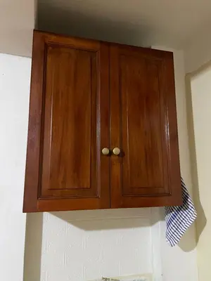 a wooden cabinet hanging on the wall in a kitchen at Departamento amplio y cómodo a 15 minutos del aeropuerto in Lima