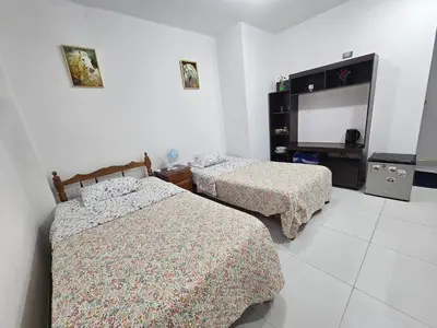 a bedroom with two beds and a television in it at Familiar Premium Twin Chanchamayo in La Merced
