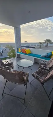 a balcony with two chairs and a bed and a boat at SKY HOUSE con vista al mar in Chincha Baja