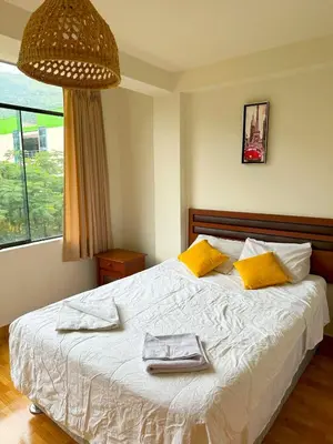 a bedroom with a bed with two towels on it at Departamento Maranura Quillabamba in Maranura