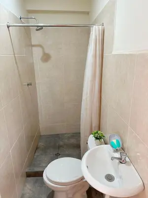 a bathroom with a toilet and a sink and a shower at Departamento Maranura Quillabamba in Maranura