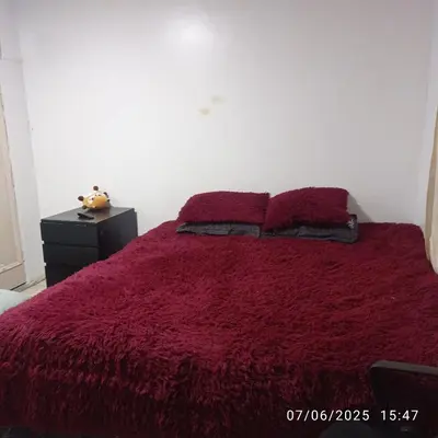 a bedroom with a red bed with two pillows at Colibri - Hab Triple in Lima