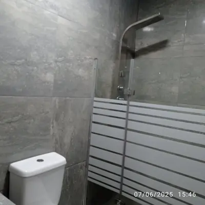 a bathroom with a white toilet and a shower at Colibri - Hab Triple in Lima