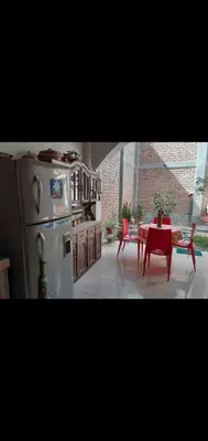 a kitchen with a table and a white refrigerator at Noah'house in Nazca