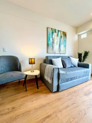 a living room with a blue couch and a chair at Ocean view 1 BR Miraflores with parking in Lima