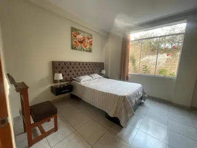 a bedroom with a bed and a window at Refugio en Cieneguilla relax, piscina y sol in Cieneguilla