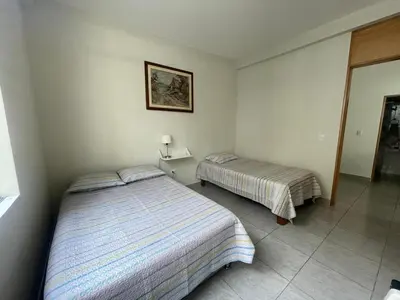 a bedroom with two beds and a mirror at Refugio en Cieneguilla relax, piscina y sol in Cieneguilla