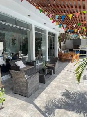 a patio with wicker chairs and tables and a dining area at Refugio en Cieneguilla relax, piscina y sol in Cieneguilla