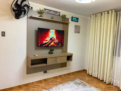 a living room with a flat screen tv on a wall at Amanecer Refugio Ideal Cozy Retreat in Los Olivos in Lima