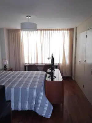 a bedroom with a bed and a desk with a television at Miraflores, Lima, habitación independiente in San Antonio