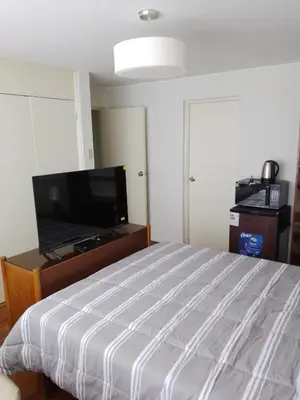 a bedroom with a bed and a flat screen tv at Miraflores, Lima, habitación independiente in San Antonio