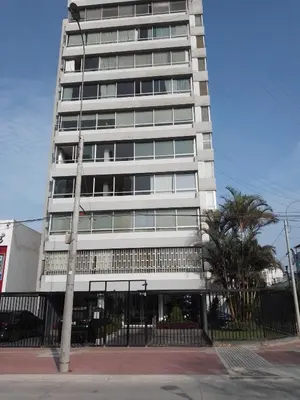a tall white building with a street light in front of it at Miraflores, Lima, habitación independiente in San Antonio