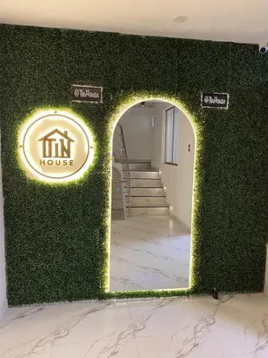 a room with a green wall with a sign on it at El Encanto Espacio Calido A warm space in Los Olivos in Lima