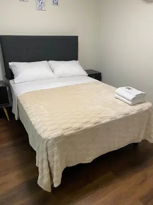 a bed with a blanket on top of it at El Encanto Espacio Calido A warm space in Los Olivos in Lima