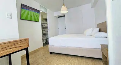 a bedroom with a bed with a tv on a wall at Suite Ocean View con WiFi San Miguel 1502 in Lima