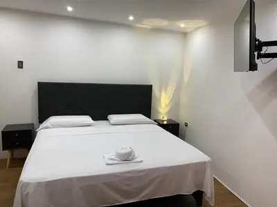 a bedroom with a white bed with a black headboard at Brisa Dorada - Luxury Apartment in Los Olivos in Lima