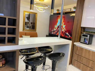 a bar with stools in a room with a tv at Brisa Dorada - Luxury Apartment in Los Olivos in Lima