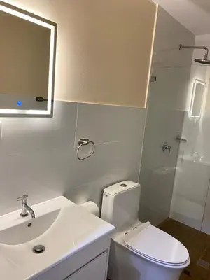 a bathroom with a toilet and a sink and a mirror at Brisa Dorada - Luxury Apartment in Los Olivos in Lima