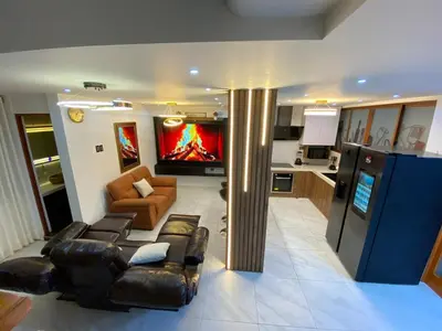 a living room with a leather couch and a tv at Brisa Dorada - Luxury Apartment in Los Olivos in Lima