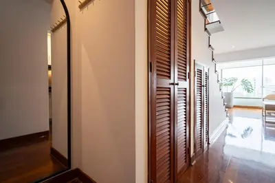 a hallway with a mirror and wooden shutters in a house at Luxury Duplex Stunning Golf Views - Prime Location in Lima