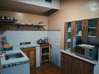 a small kitchen with a sink and a microwave at Casa Aguilar in Urubamba