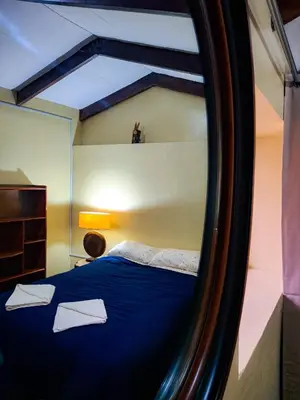 a mirror reflection of a bed with two white pillows at Casa Aguilar in Urubamba
