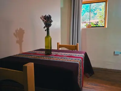 a vase with flowers in it sitting on a table at Casa Aguilar in Urubamba