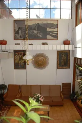 a living room with a couch and pictures on the wall at Hotel WhiteHouse in Cusco