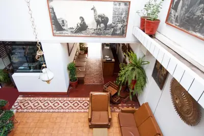 a view of a hallway with chairs and plants at Hotel WhiteHouse in Cusco