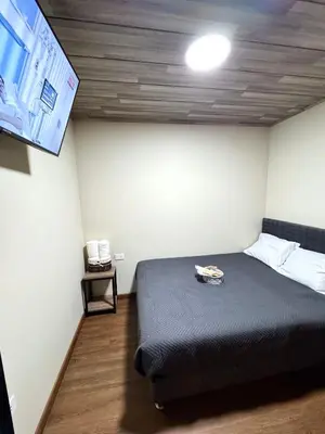 a room with a bed and a flat screen tv at Casa Cusco in Cusco