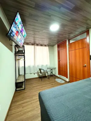 a room with a bed and a tv and a table at Casa Cusco in Cusco