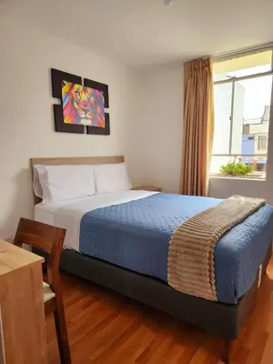a bedroom with a bed and a table and a window at Casa Victoria in Lima