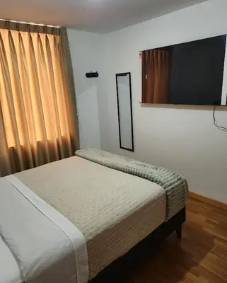 a bedroom with a bed and a mirror and curtains at Casa Victoria in Lima
