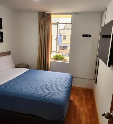 a bedroom with a blue bed and a window at Casa Victoria in Lima
