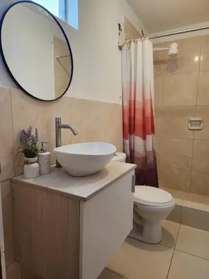 a bathroom with a sink and a toilet and a mirror at Casa Victoria in Lima
