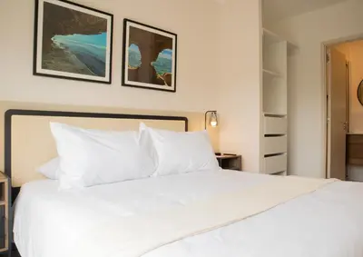 a bedroom with a white bed with two pictures on the wall at Salaverry by Wynwood House in Lima