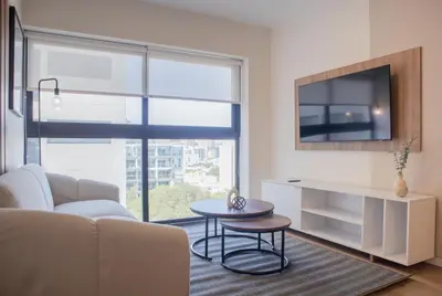 a living room with a couch and a tv and a table at Salaverry by Wynwood House in Lima