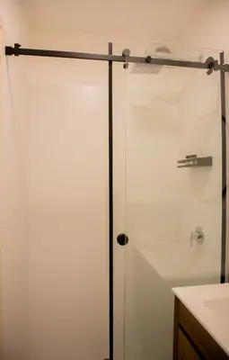 a glass shower door in a bathroom with a sink at Salaverry by Wynwood House in Lima
