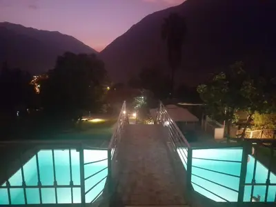 a bridge over a swimming pool at night at Nice country house with pool and beautiful view in Huarochirí