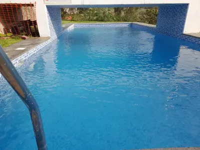 a swimming pool with blue water at Nice country house with pool and beautiful view in Huarochirí