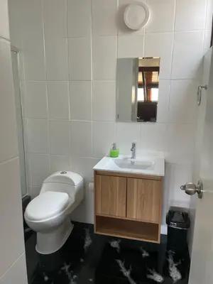 a bathroom with a toilet and a sink at SAELUMA Suite Apart in Lima