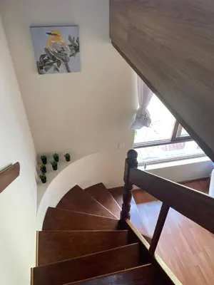 a staircase in a house with a wooden stair case at SAELUMA Suite Apart in Lima