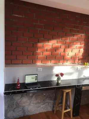a counter with a laptop computer on a brick wall at Casa de Marguito in Urubamba